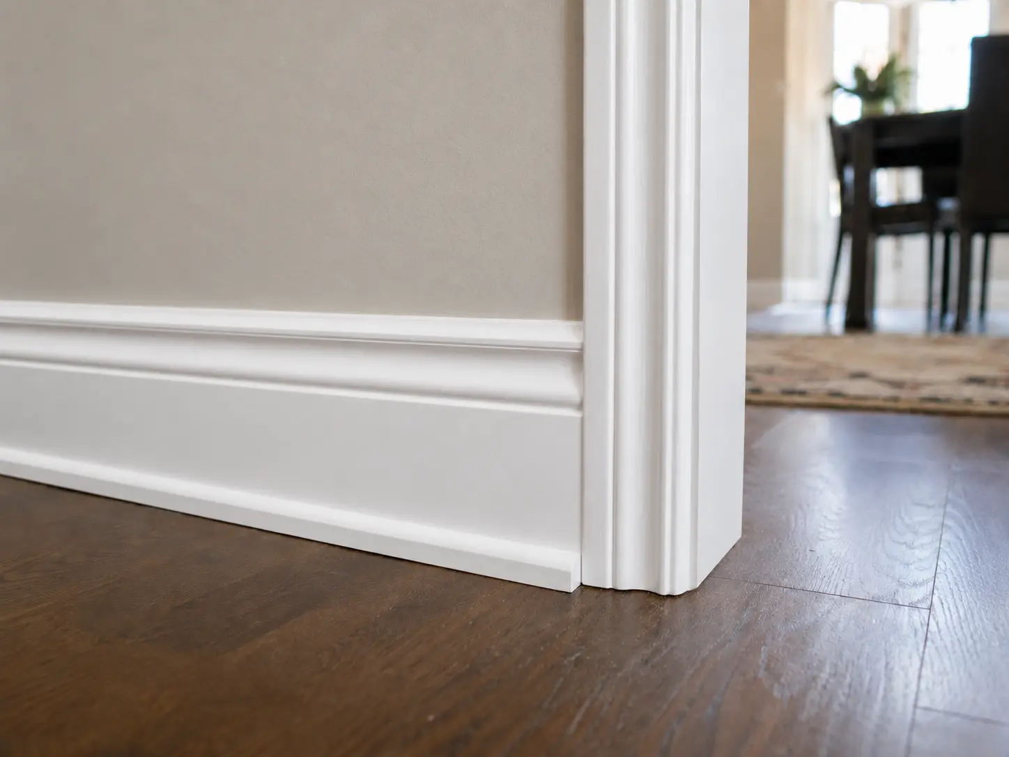 New baseboard with clean caulk lines and finished paint